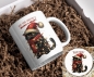 Preview: Weihnachtstasse mit lustigem Katzenmotiv und passendem Untersetzer: Eine schwarze Katze mit rotem Schal und Weihnachtsmütze ist in eine leuchtende Lichterkette eingewickelt. Über dem Motiv steht der Schriftzug ‚Hope your Christmas is Meowy & Bright‘ in fe